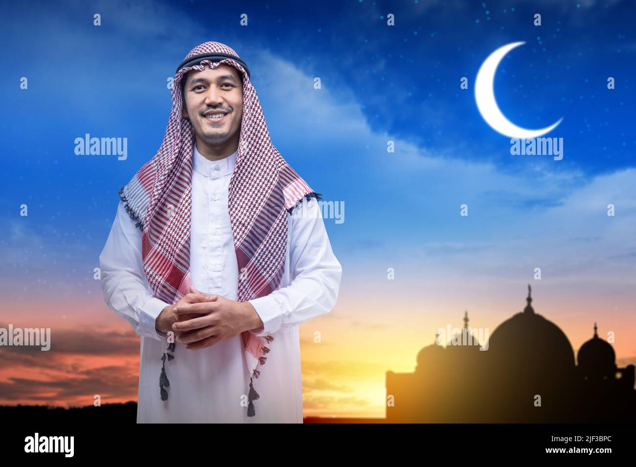 Homme arabe portant le keffiyeh debout avec la silhouette de la mosquée et le fond de la scène de nuit Banque D'Images