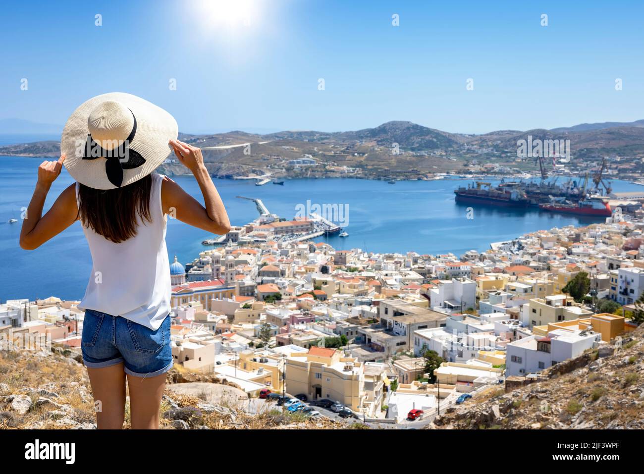 Une touriste avec chapeau bénéficie de la vue sur la ville d'Ermoupoli Banque D'Images