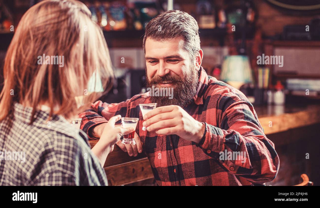 Femme boisson alcoolisée au bar. La jeune femme a des problèmes d'alcool. Alcoolisme féminin. Jeune homme qui boit de l'alcool Banque D'Images