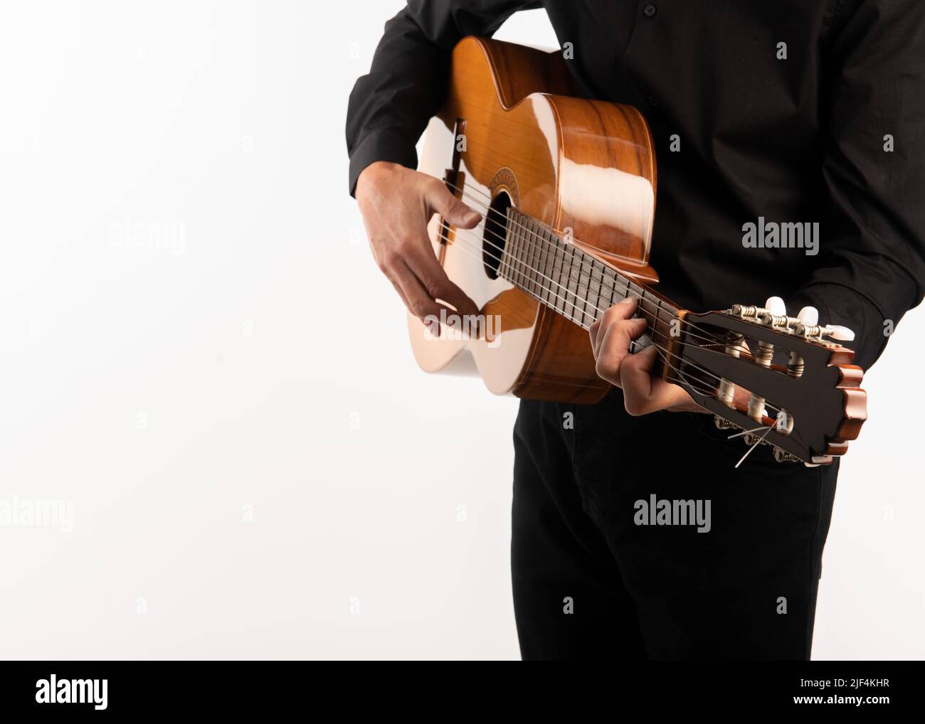 Guitare classique isolée et mains du guitariste se tunent de près sur fond blanc. Banque D'Images