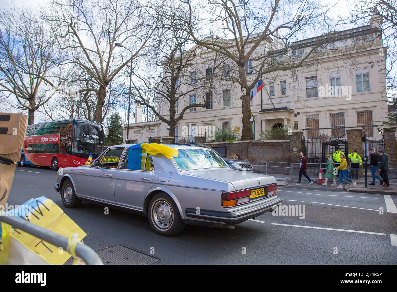 Un automobiliste affichant des drapeaux ukrainiens sur la voiture passe devant l'ambassade de Russie à Londres. Banque D'Images