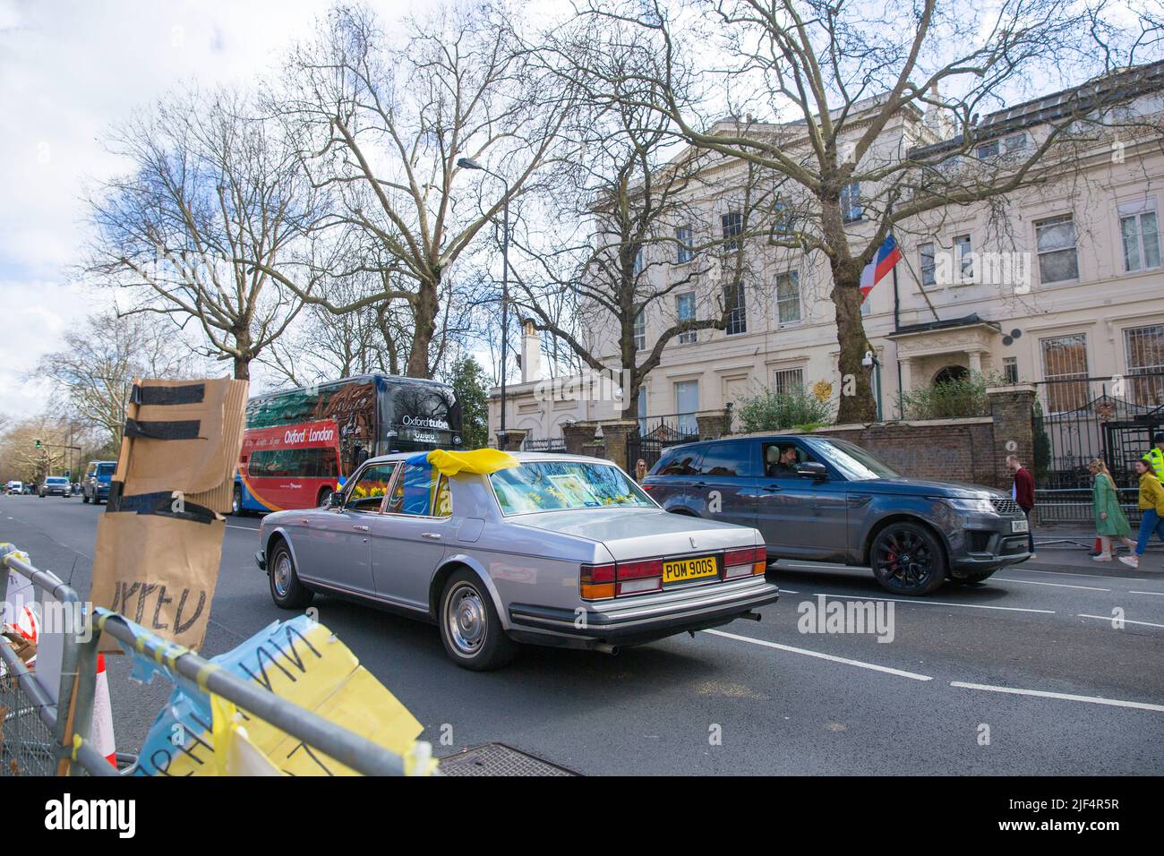 Un automobiliste affichant des drapeaux ukrainiens sur la voiture passe devant l'ambassade de Russie à Londres. Banque D'Images