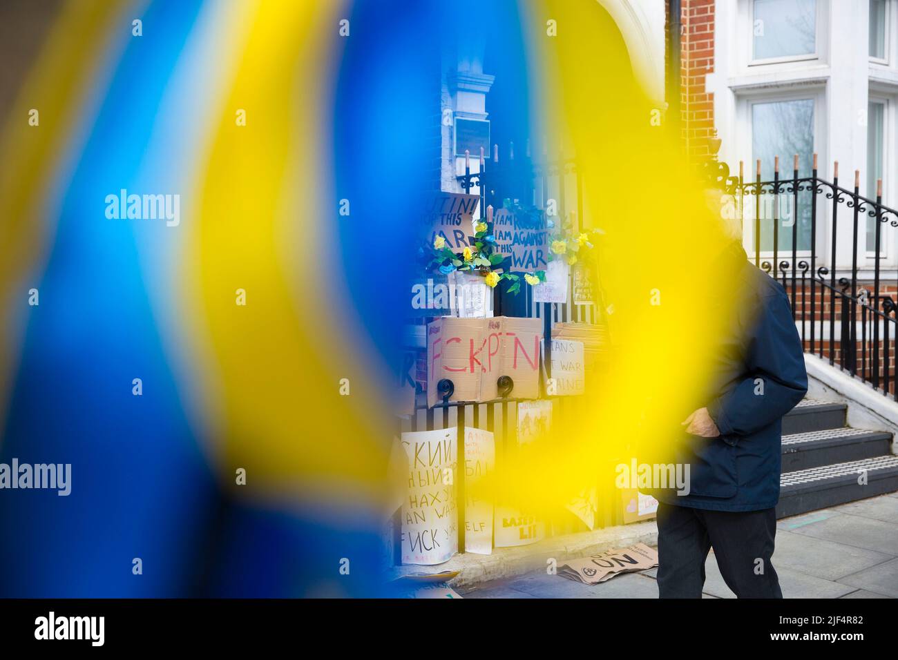 On voit des rubans bleus et jaunes attachés à un arbre tandis que les messages contre l’invasion de l’Ukraine par la Russie sont laissés près de l’ambassade de Russie à Londres. Banque D'Images