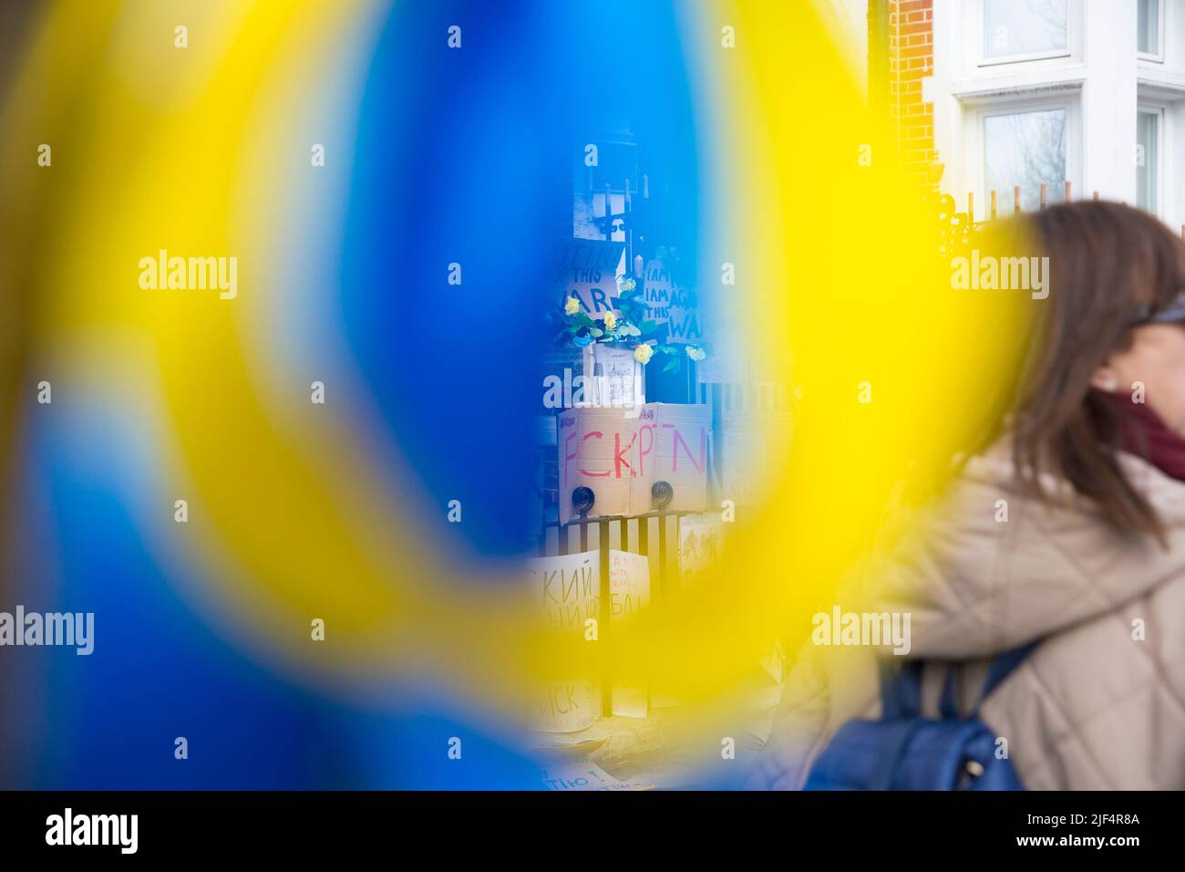 On voit des rubans bleus et jaunes attachés à un arbre tandis que les messages contre l’invasion de l’Ukraine par la Russie sont laissés près de l’ambassade de Russie à Londres. Banque D'Images