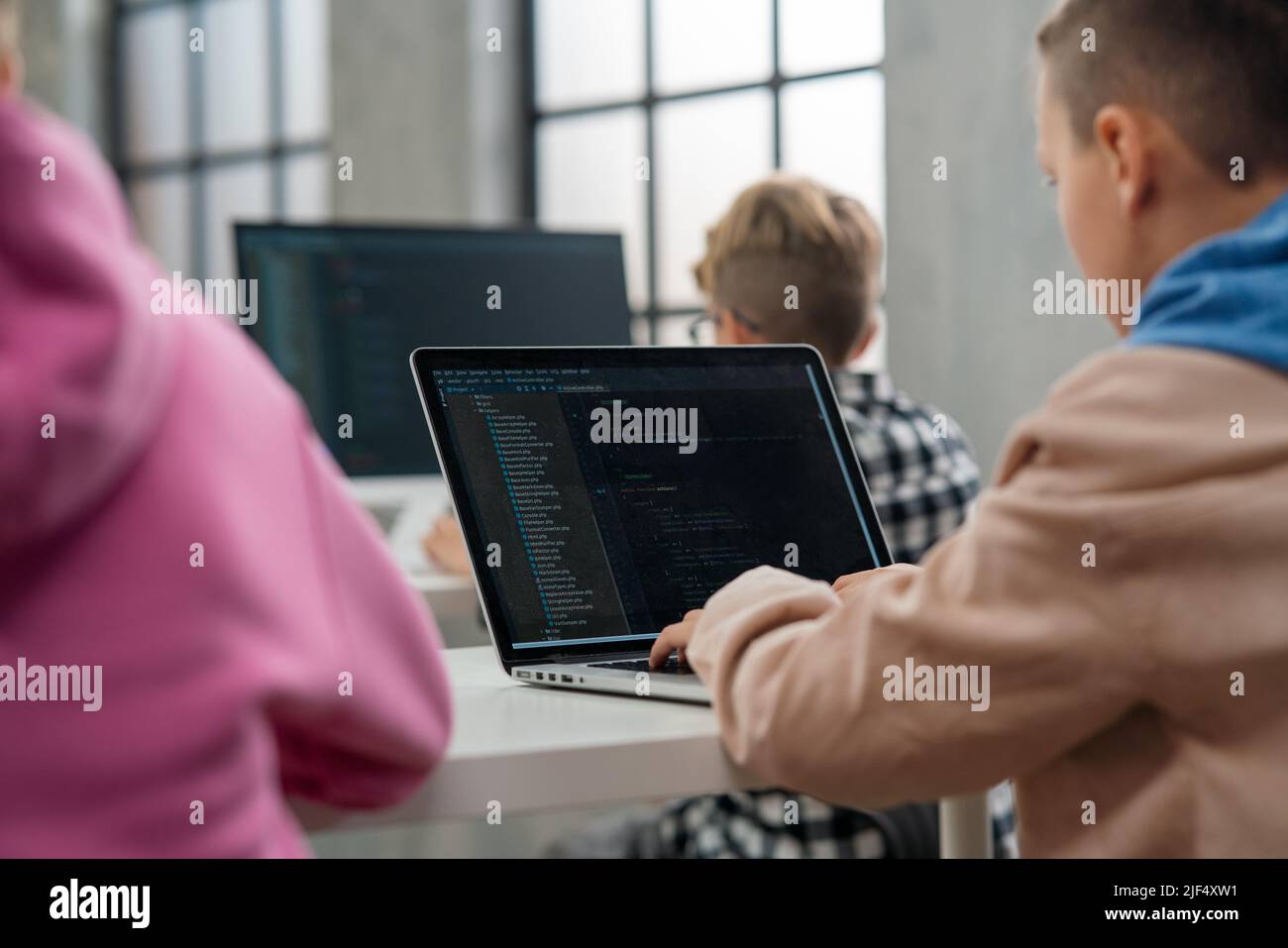 Vue en grand angle des enfants de l'école en utilisant l'ordinateur dans la salle de classe à l'école Banque D'Images