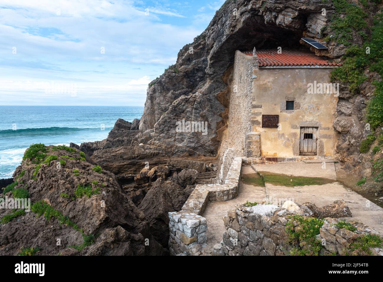 L'Ermitage de Santa Justa est sculpté dans la roche d'une falaise au-dessus de la mer de Cantabrie, ville d'Ubiarco en Cantabrie, Espagne Banque D'Images
