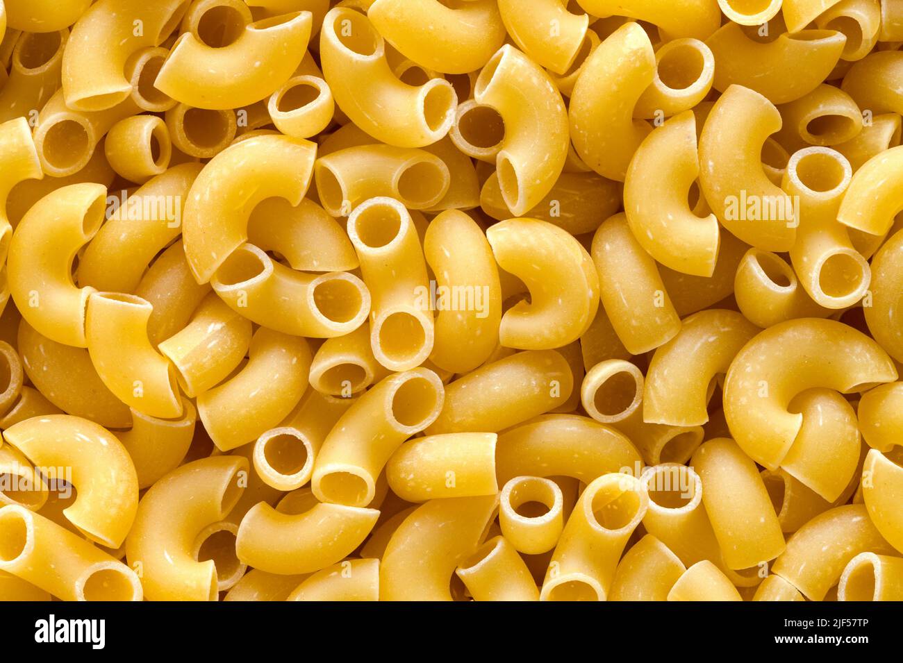 Dry Elbow Pasta Macaroni Noodles fond de pile. Banque D'Images