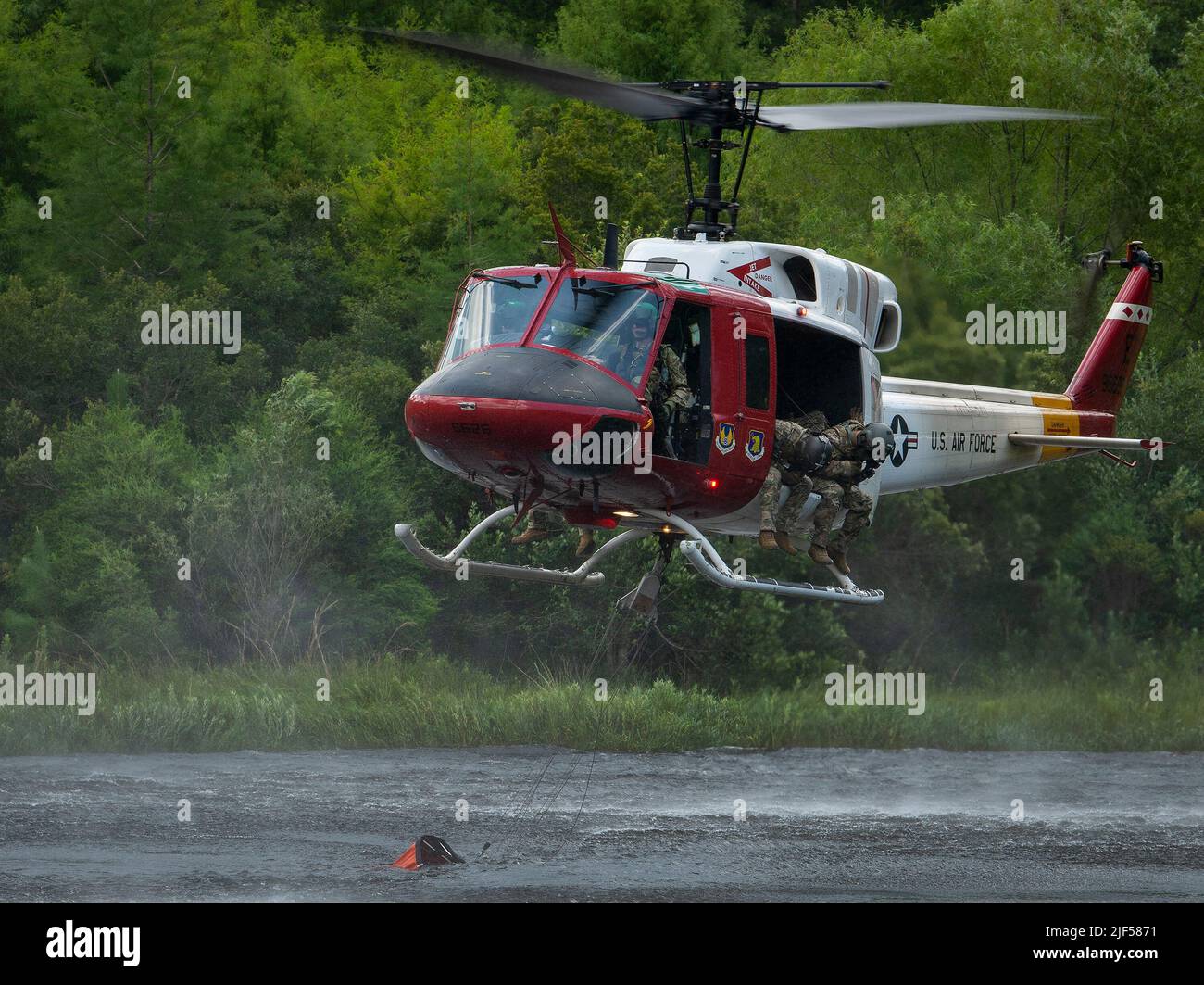 Un escadron d'essai de vol 413th UH-1 Huey remplit un seau d'eau de l'étang Anderson pendant une mission d'entraînement 28 juin à la base aérienne d'Eglin, en Floride. La formation sur les opérations des seaux d'eau est nécessaire pour que les équipages de vol maintiennent leurs compétences en matière de lutte contre les incendies. Les hélicoptères FLTS 413th peuvent être chargés par l'escadre d'essai 96th de soutenir Jackson Guard dans la gestion des incendies. (É.-U. Photo de la Force aérienne/Samuel King Jr.) Banque D'Images