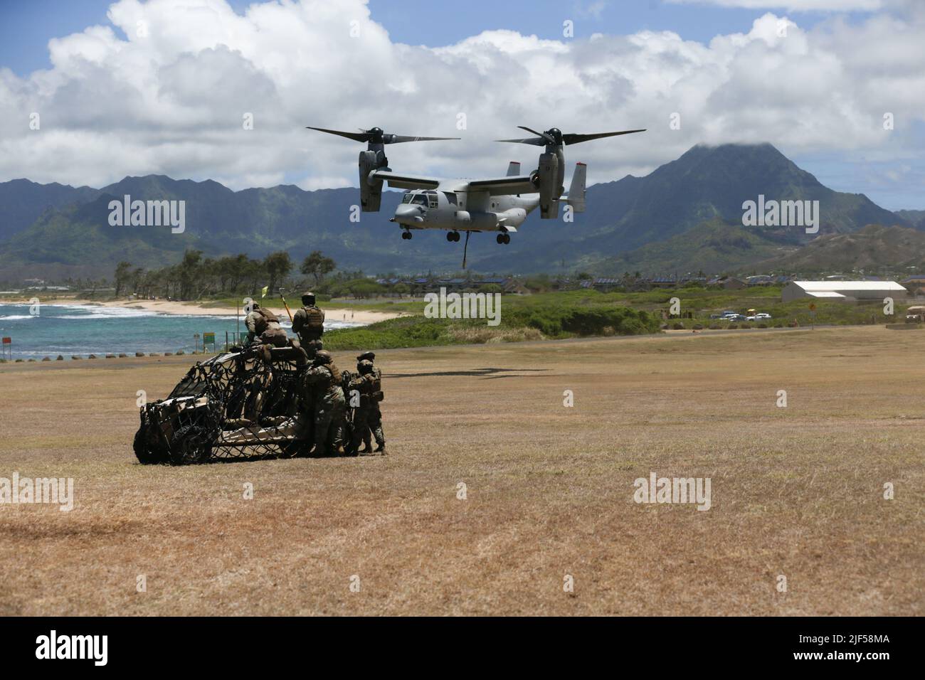 Un Marines corps MV-22 Osprey des États-Unis avec le Marine Medium Tiltrotor Squadron 363, aux côtés des avions américains avec le 921st Contingency Response Squadron, dirige un ascenseur aérien externe à la zone d'atterrissage Eagle, à la base des Marines Hawaii, 24 juin 2022. L'exercice a été mené entre le 1st Bataillon, 12th Marines, le 3 Bataillon de logistique de combat, VMM-363 et 921st CRS, afin de faire progresser les initiatives d'intégration et d'expérimentation de la force conjointe, à l'appui de Force Design 2030. (É.-U. Photo du corps marin par lance Cpl. Terry Stennet III) Banque D'Images