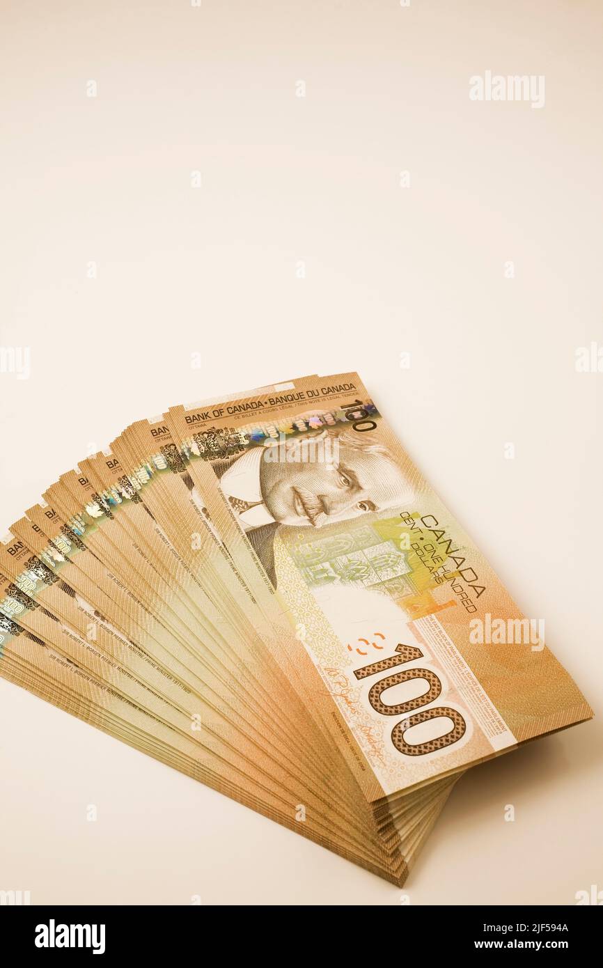 Pile de dix mille dollars en billets de banque canadiens d'une centaine de dollars. Banque D'Images