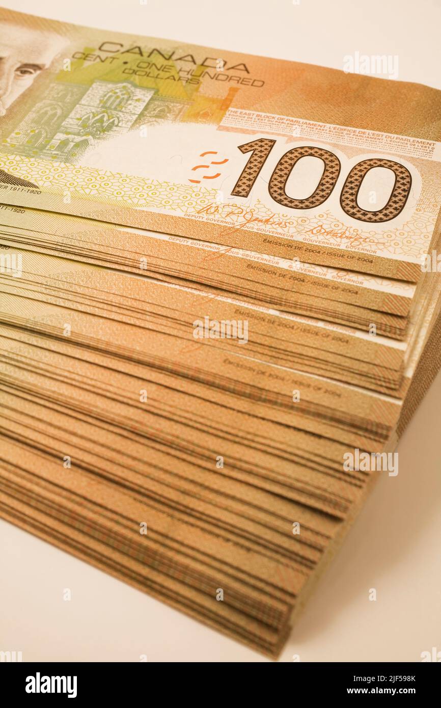 Pile de dix mille dollars en billets de banque canadiens d'une centaine de dollars. Banque D'Images