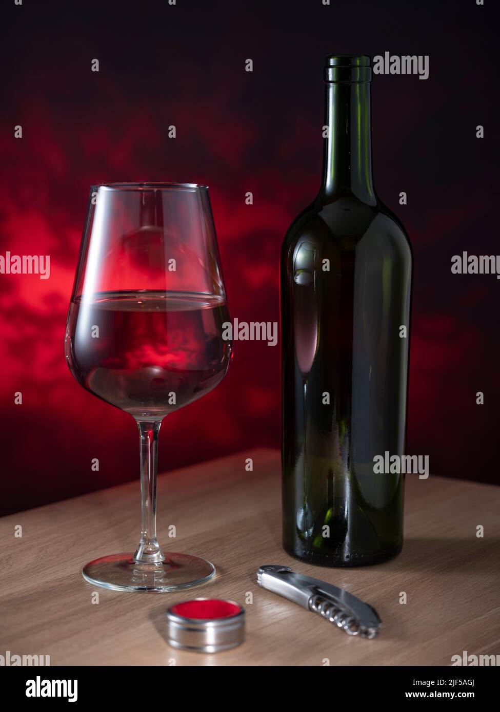 Helsinki / Finlande - 26 JUIN 2022 : une bouteille de vin rouge, un verre et un tire-bouchon sur fond sombre Banque D'Images