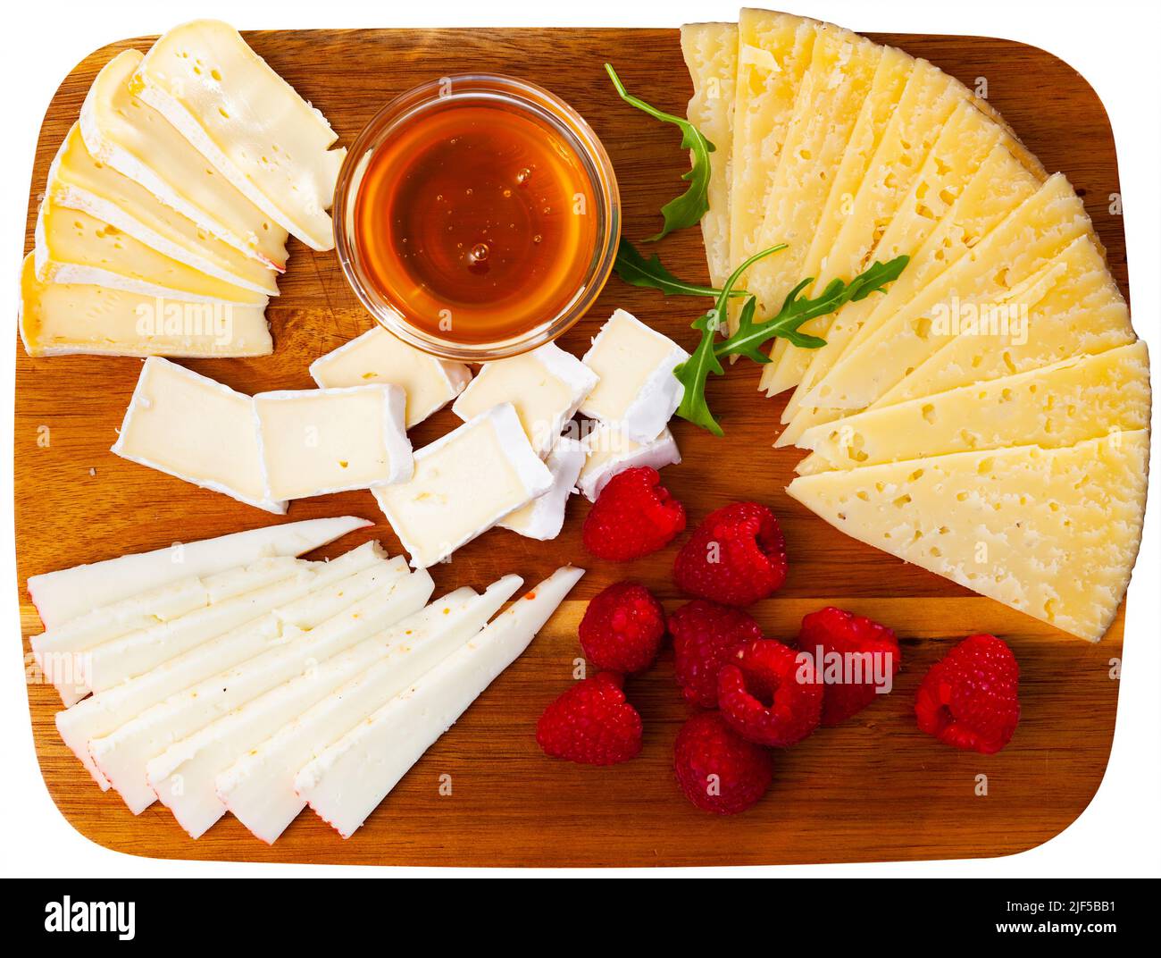 Différents types de fromage tranchés et servis sur une planche en bois Banque D'Images