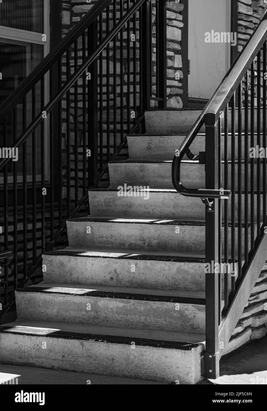 Escalier et lumière du soleil. Entrée du bâtiment. Éléments rambarde d'une maison. Marchepied avec main courante en acier. Personne, photo de rue, photo abstraite Banque D'Images