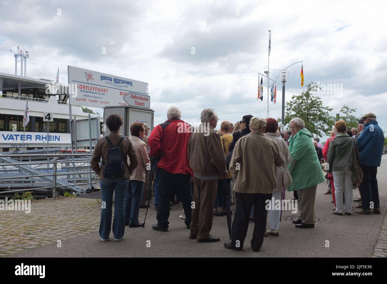Groupe de touristes âgés, des aînés sains et agiles, attendent de monter à bord du ferry de Bingen-Rudesheimer au port de Bingen am Rhein en Rhénanie-Palatinat, en Allemagne. Banque D'Images