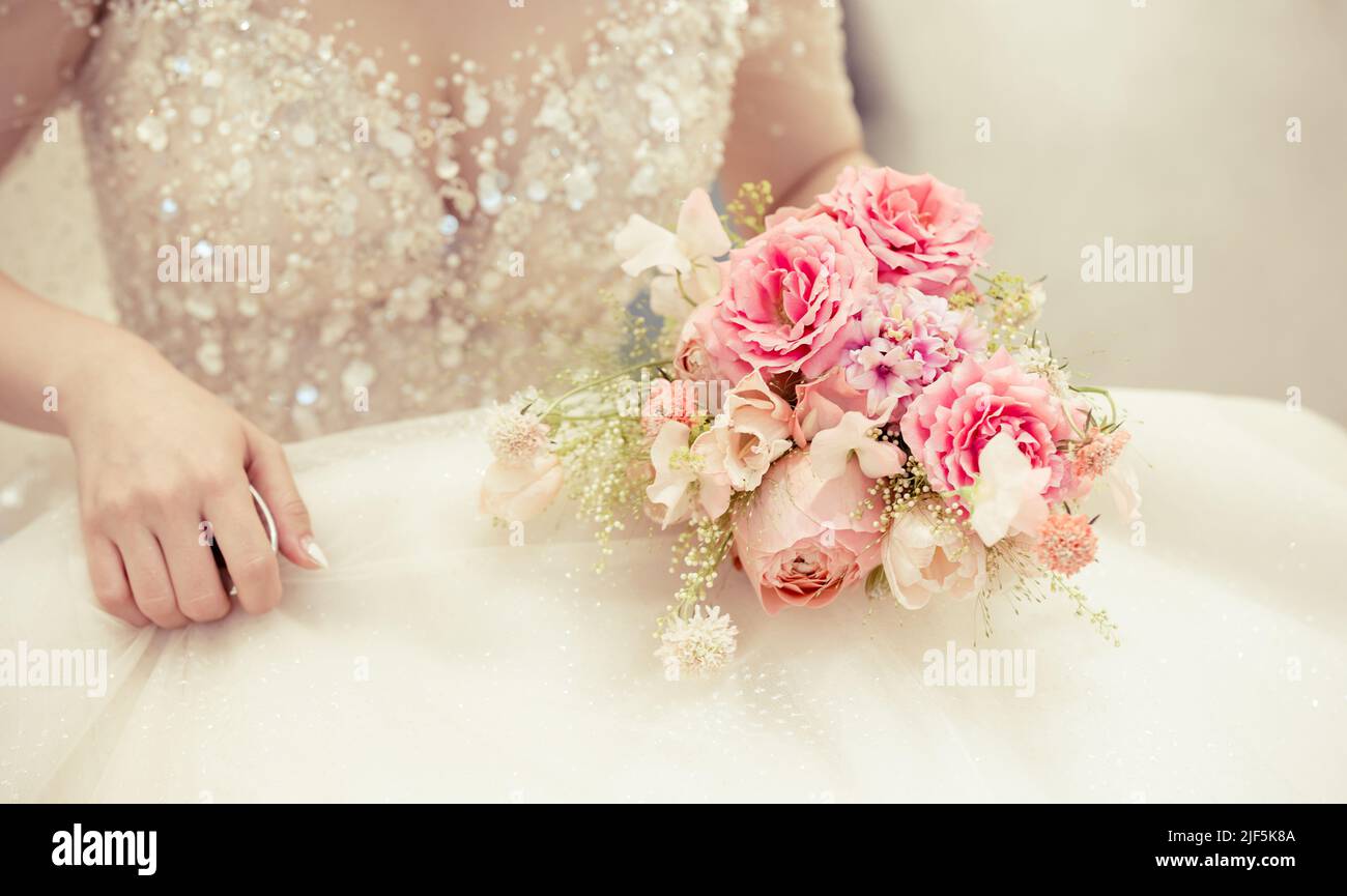Mariée tenant le bouquet de mariage, coupe d'image de détail. Banque D'Images