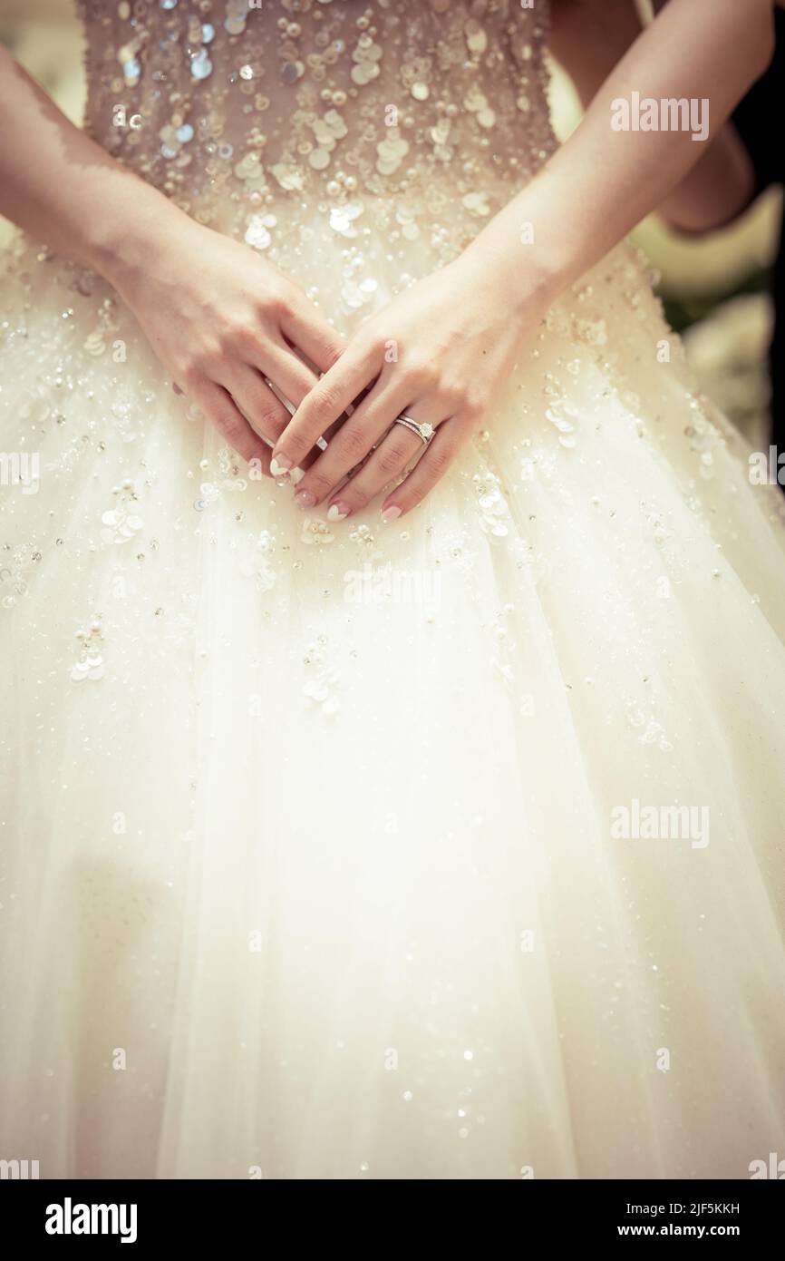 Main de mariée avec un anneau de mariage sur le fond de la robe, détail image coupée. Banque D'Images