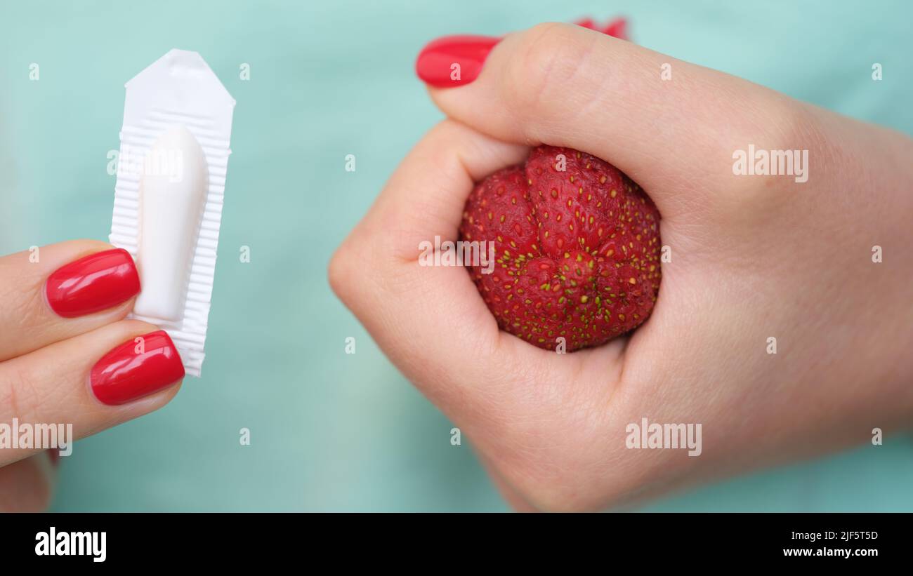 La main de femme tient des bougies médicales pour la constipation et l'anatomie de l'anus Banque D'Images