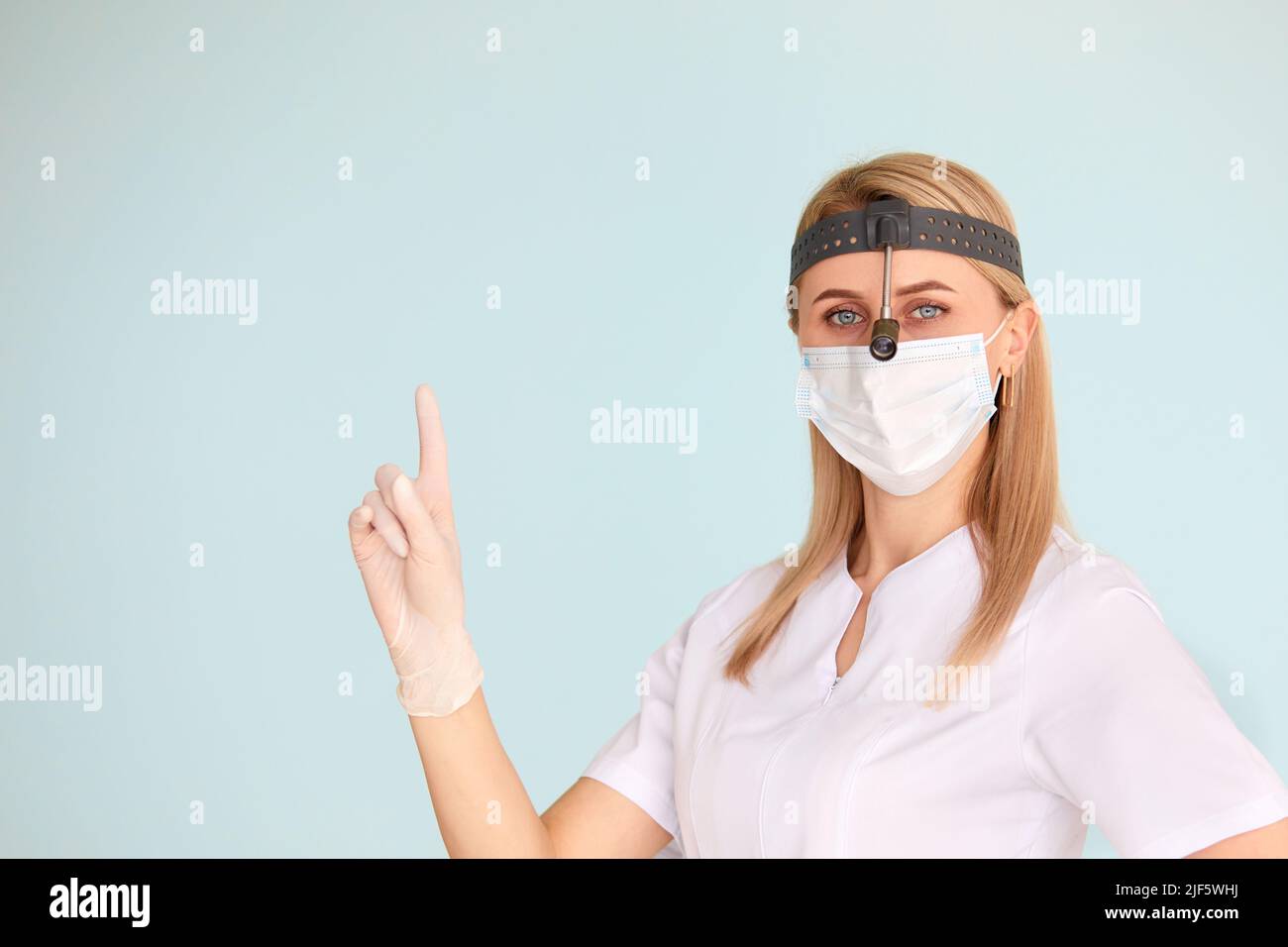 Femme médecin ORL, portant un masque à l'hôpital regardant la caméra Banque D'Images