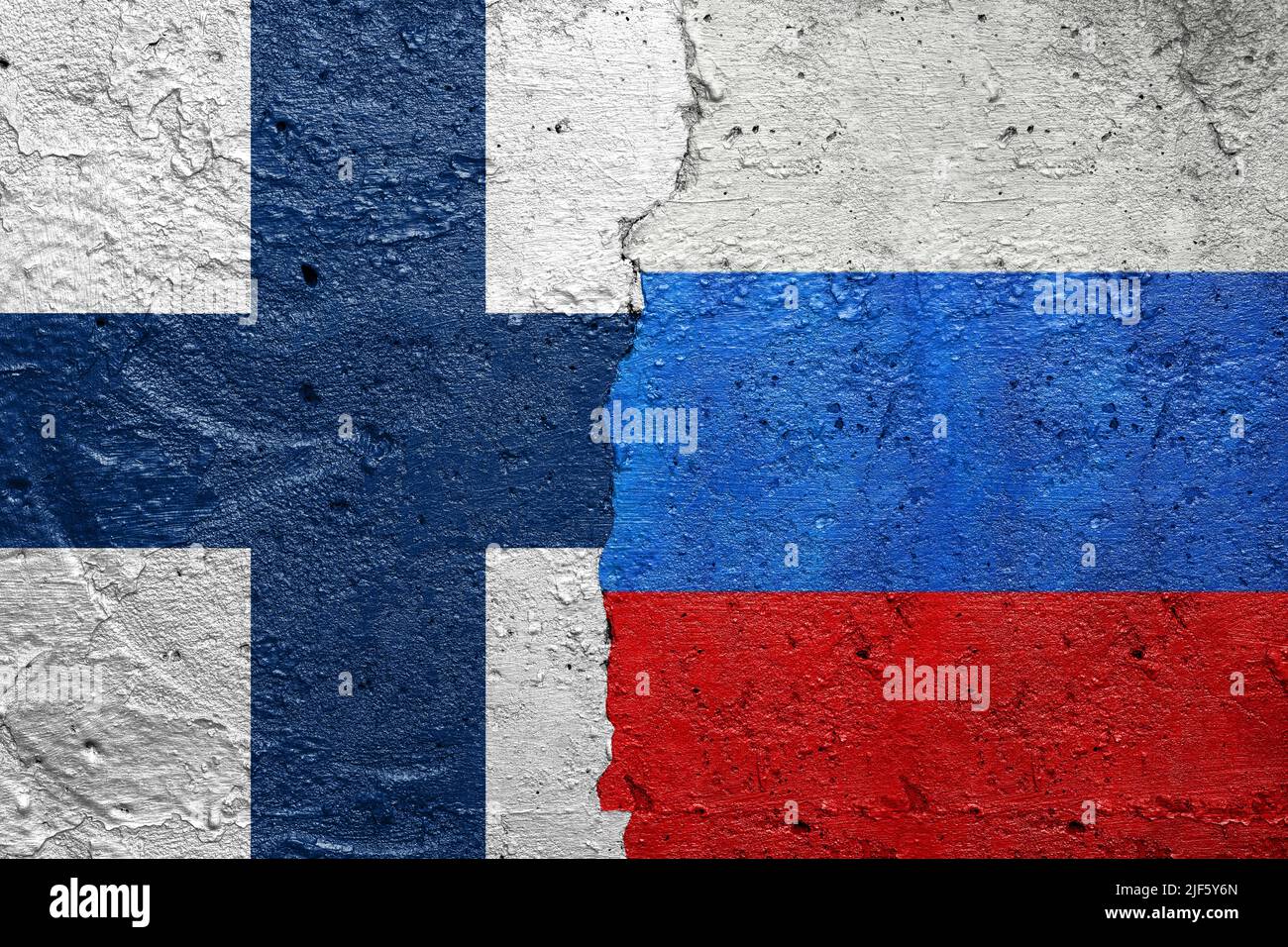 Finlande contre Russie - mur de béton fissuré peint avec un drapeau Finlandien à gauche et un drapeau russe à droite Banque D'Images