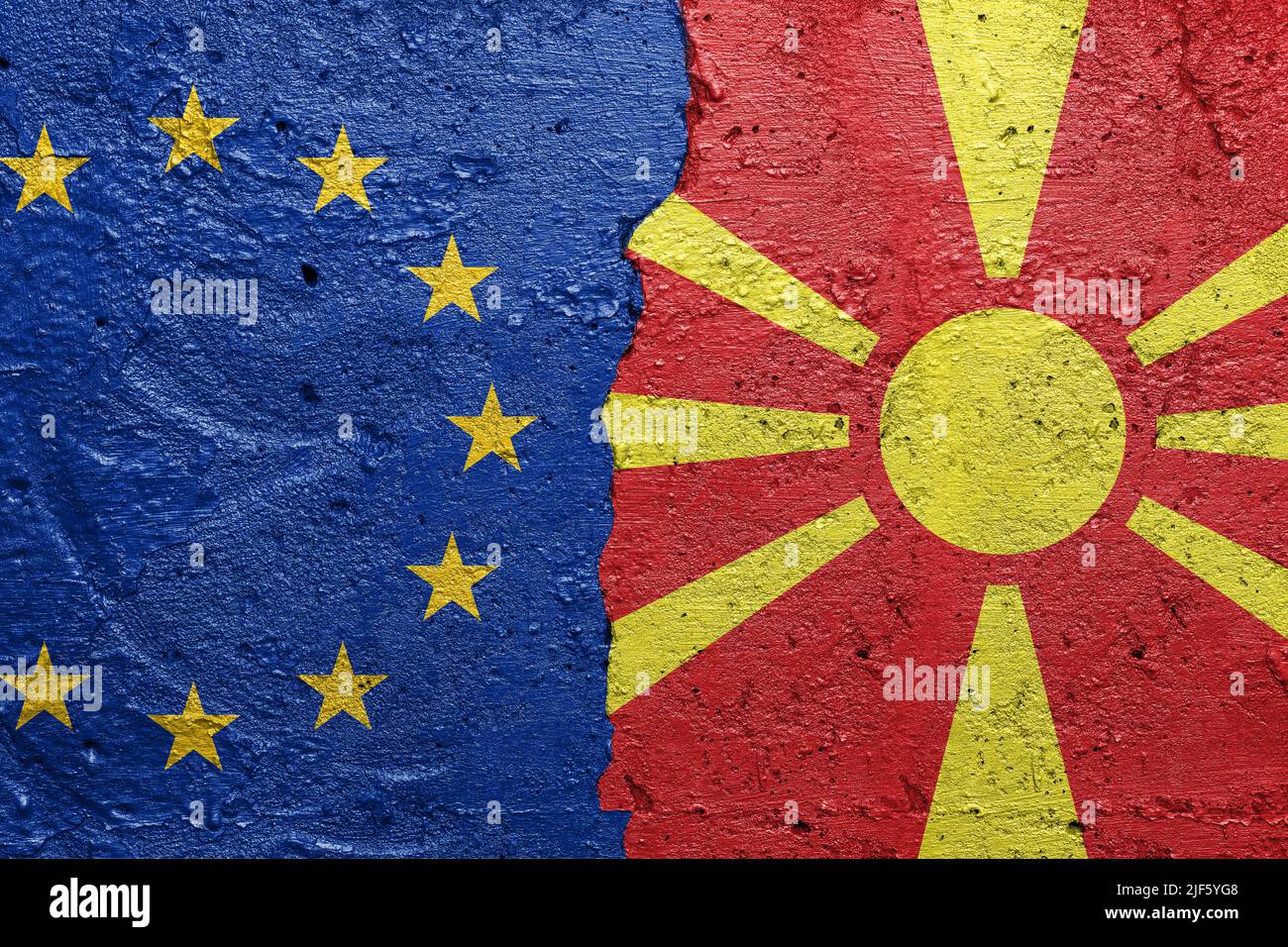 Drapeaux de l'Union européenne et de Nort Macédoine - mur en béton fissuré peint avec un drapeau de l'UE à gauche et un drapeau à droite Banque D'Images