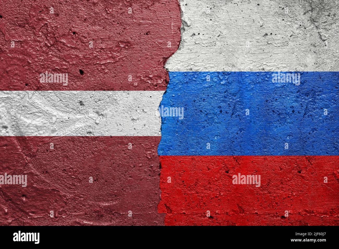 Lettonie et Russie - mur en béton fissuré peint avec un drapeau letton à gauche et un drapeau russe à droite Banque D'Images