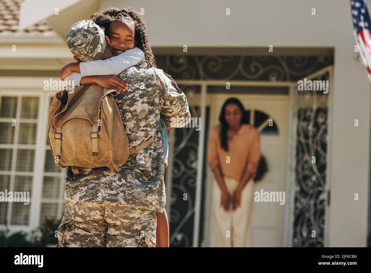 Soldat de l'armée embrassant sa fille après son retour à la maison. Un militaire américain surprend sa femme et sa fille à son retour. Militaire homme resuniti Banque D'Images