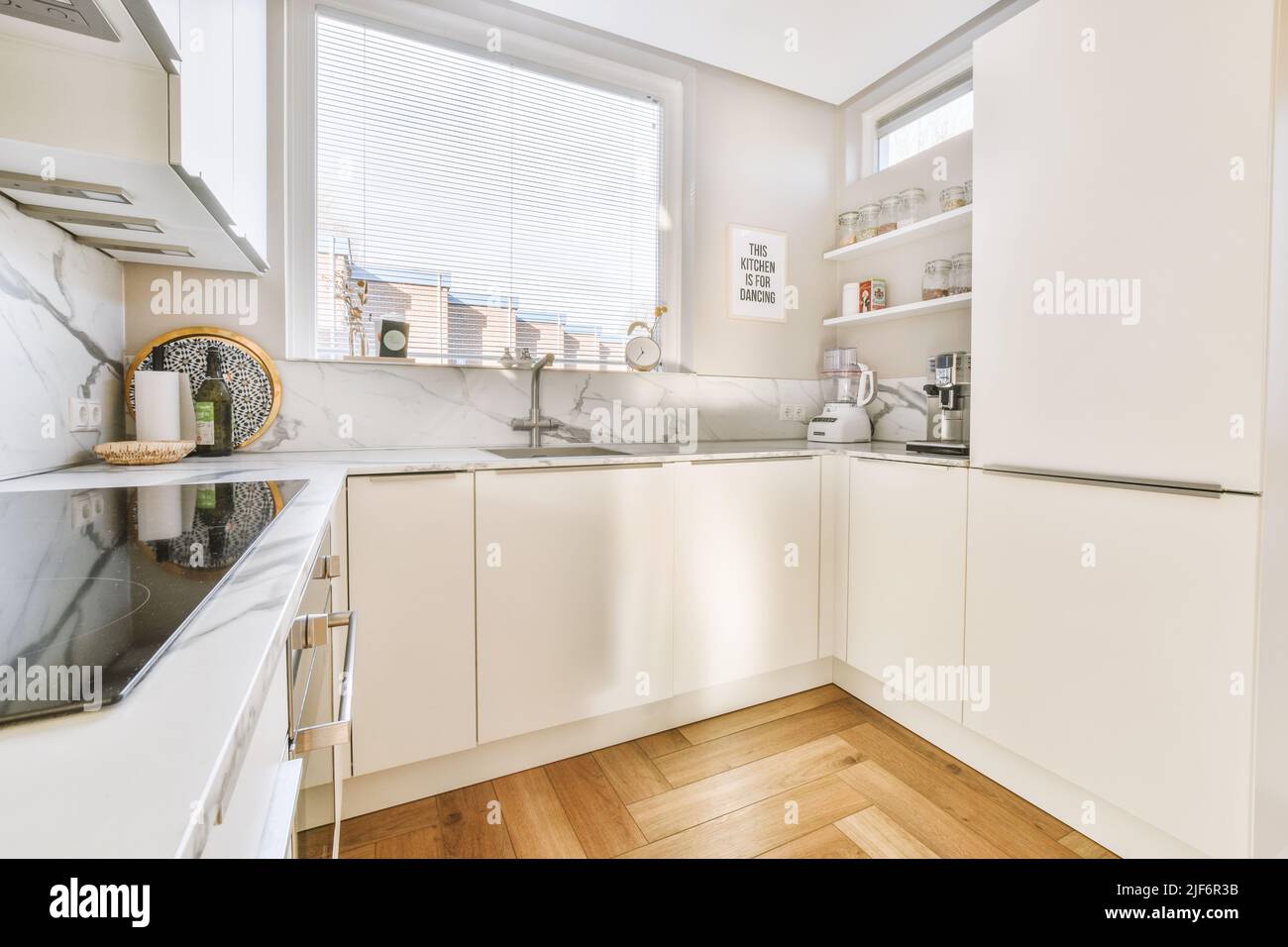 Fragment de l'intérieur de la lumière étroite cuisine maison avec style minimaliste mobilier blanc avec évier et cuisinière Banque D'Images