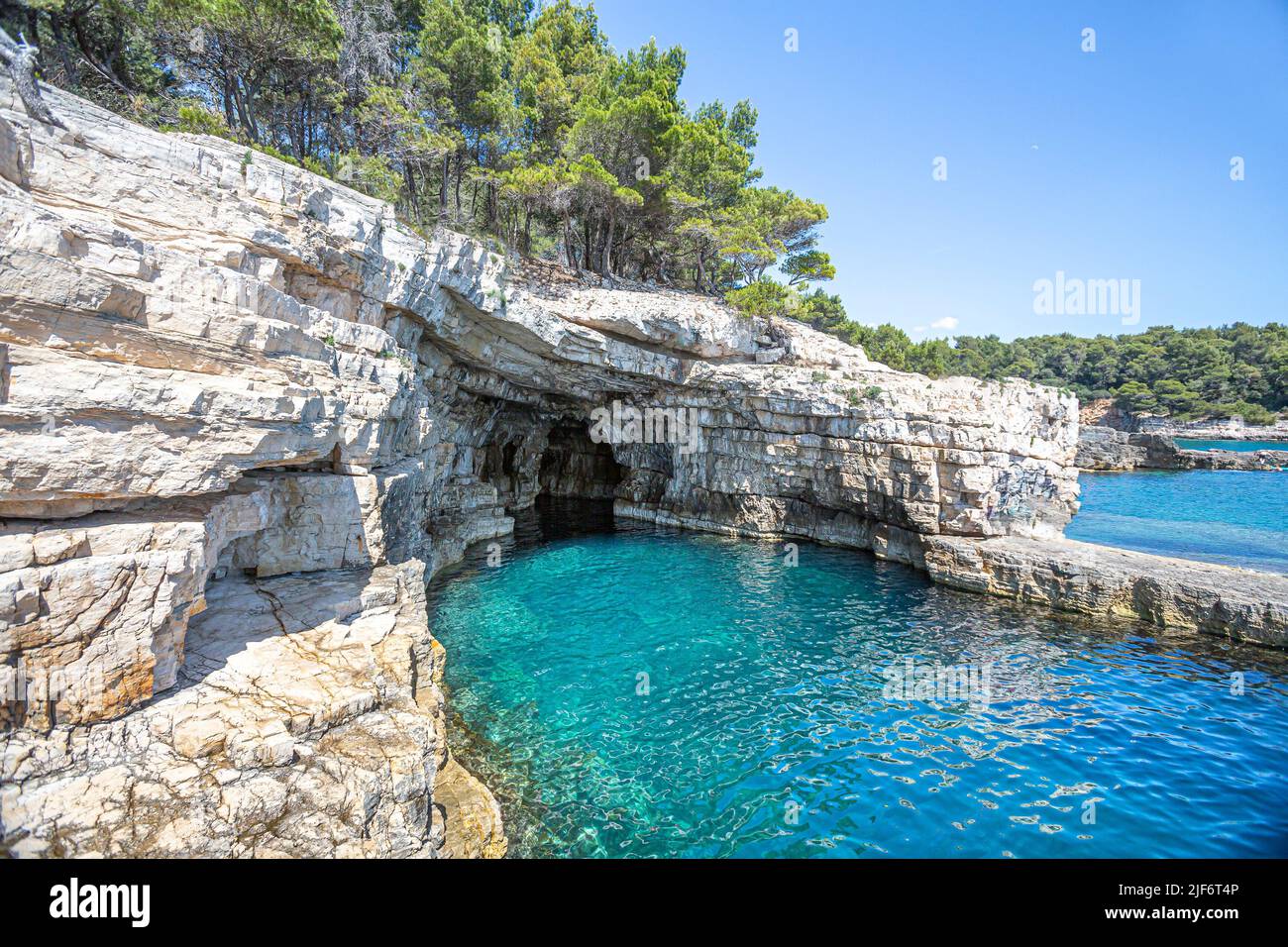 Croatie, Istrie, Pula, côte avec rochers et grotte Banque D'Images