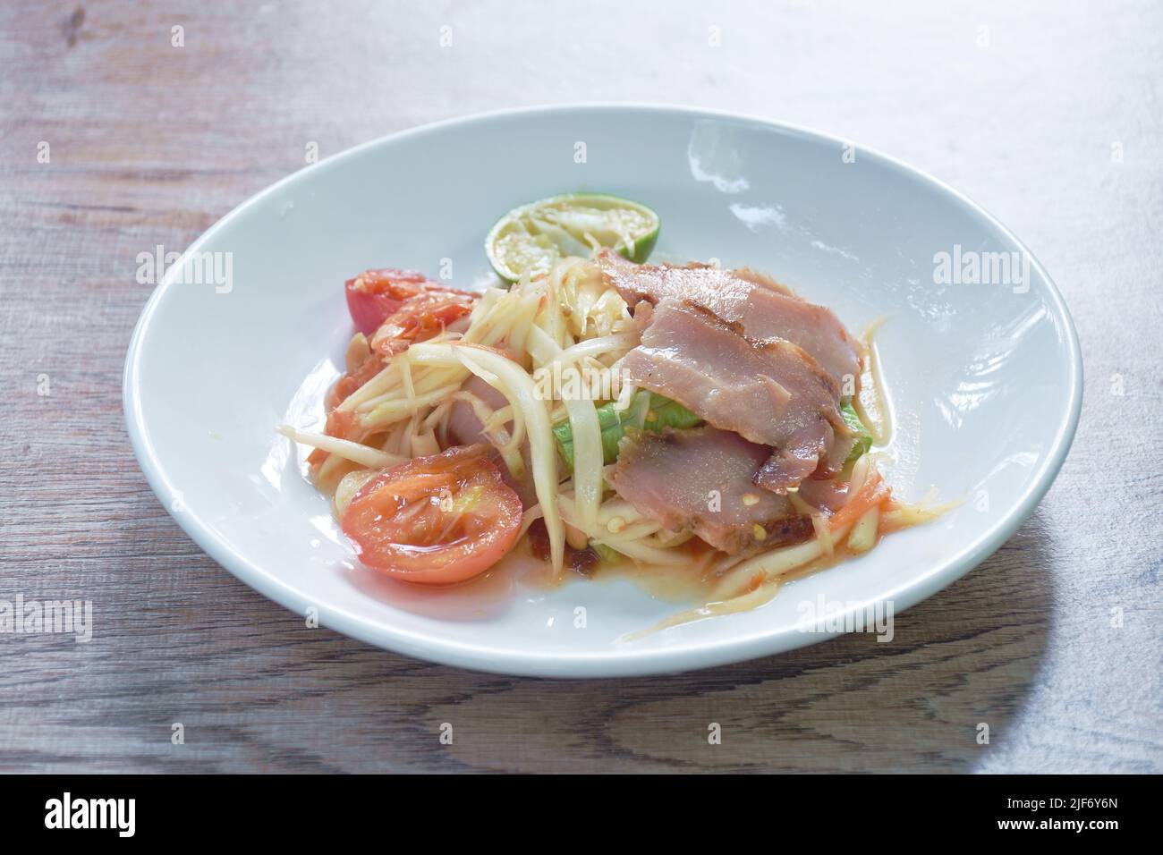 SOM tum thaï épicé de papaye verte tranche de garniture barbecue salade de porc sur l'assiette Banque D'Images