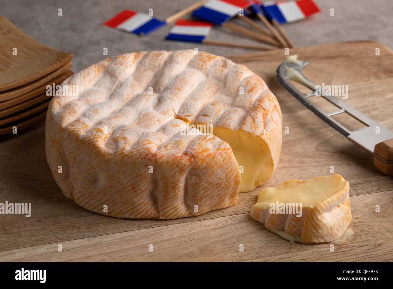 Fromage français vieilli à l'orange blanchi de la chaîne de montagnes des Vosges sur une planche à découper de près Banque D'Images