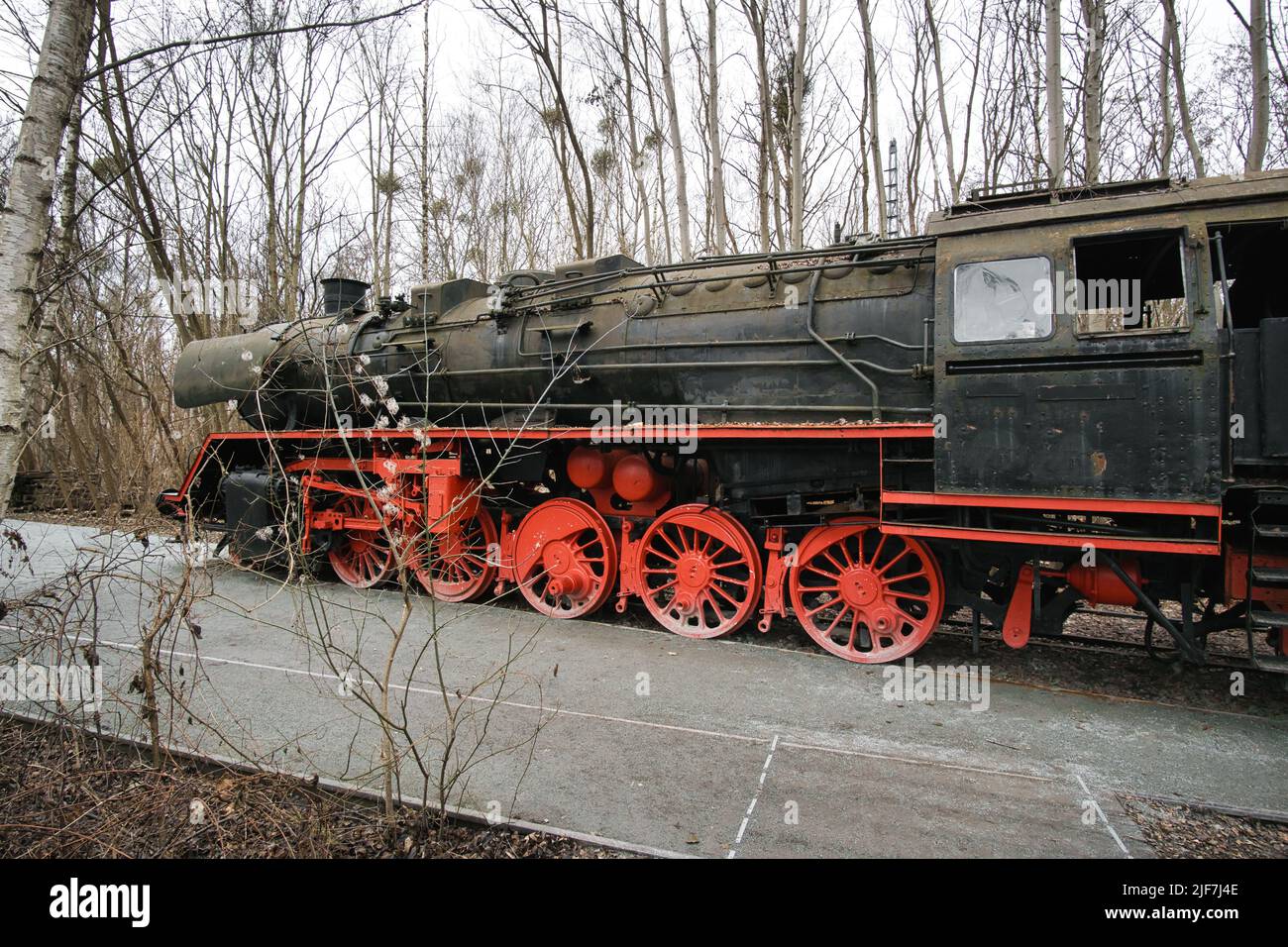 Locomotive à vapeur garée à un terminal. Chemin de fer historique de 1940 en rouge noir. Photo de nostalgie de la technologie passée Banque D'Images