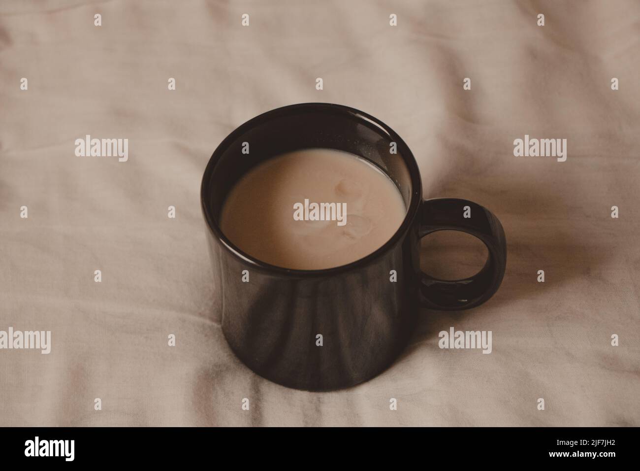 tasse noire avec latte crémeuse au lit Banque D'Images