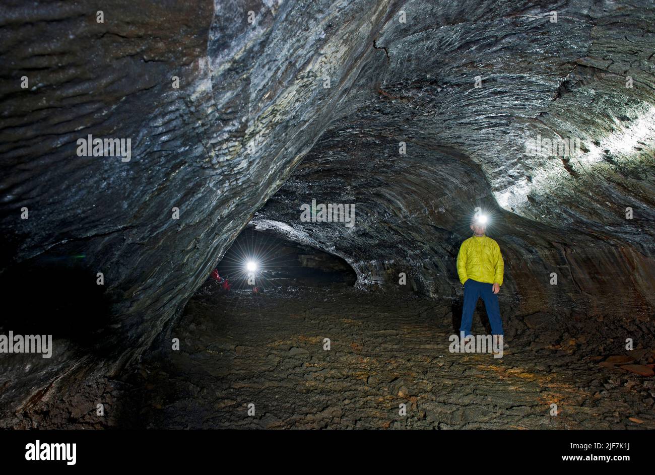 Scientifique explorant la grotte de lave de Leidarendi en Islande Banque D'Images
