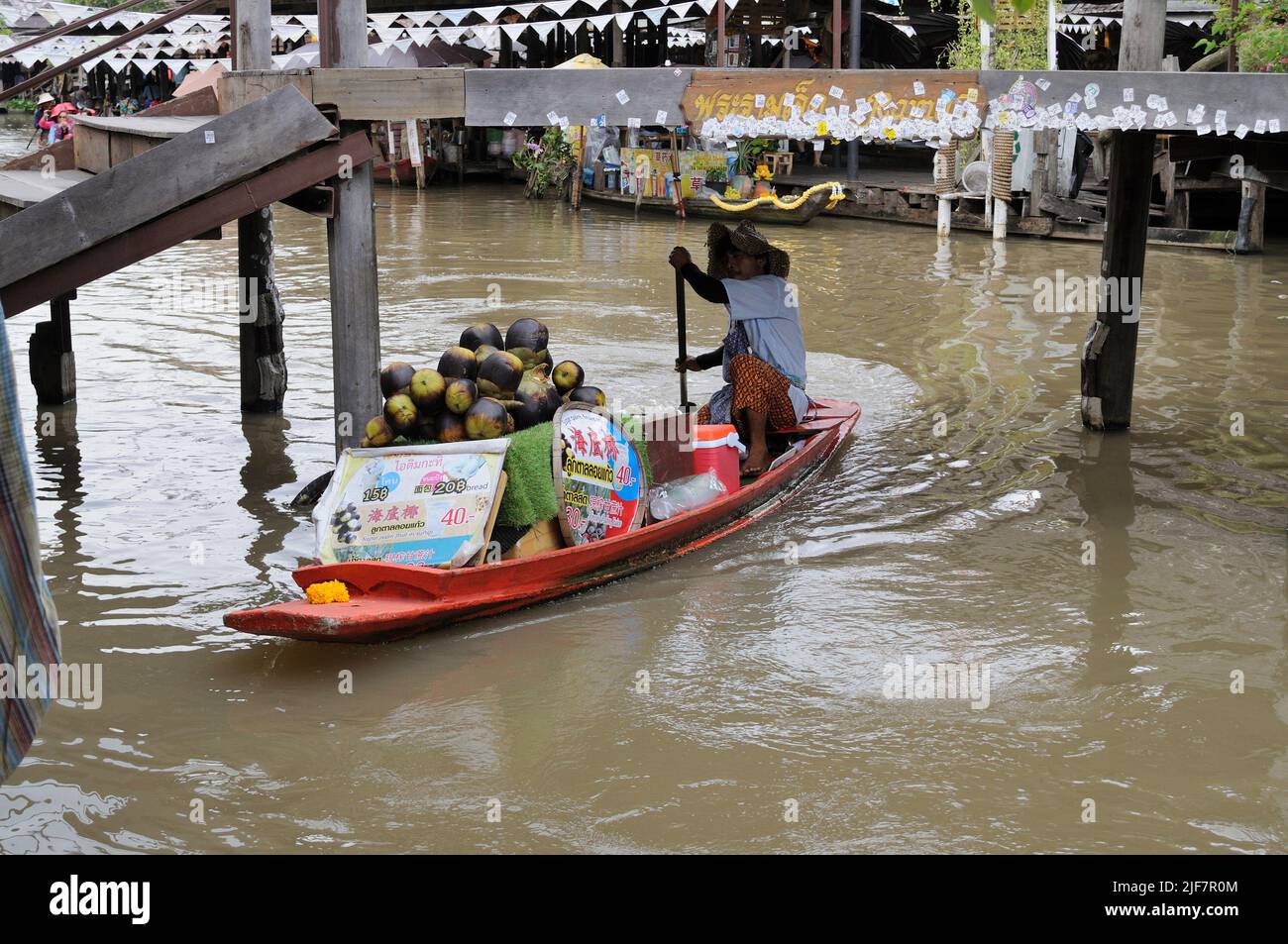 Le vendeur sur le bateau transporte des marchandises au marché flottant. Banque D'Images