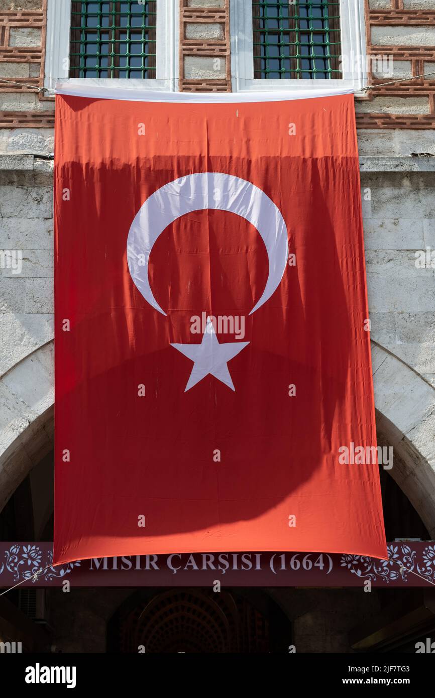 Drapeau turc suspendu au-dessus de l'entrée du marché aux épices d'Istanbul (Mistr Carsisi), Istanbul, Turquie Banque D'Images