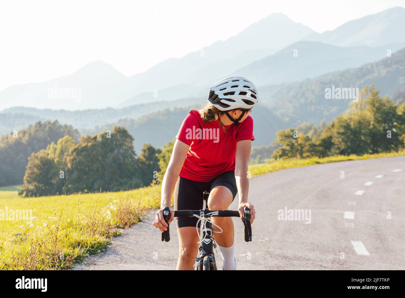 Jeune femme cycliste professionnelle pendant le sprint de vélo de route regardant derrière. Banque D'Images