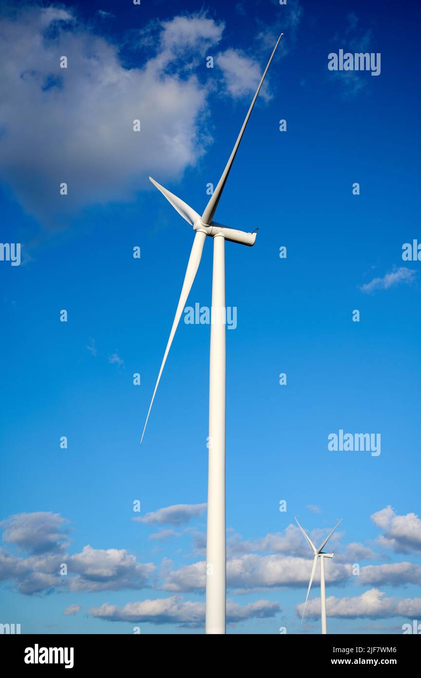 Éolienne simple contre le ciel bleu et les nuages. Banque D'Images