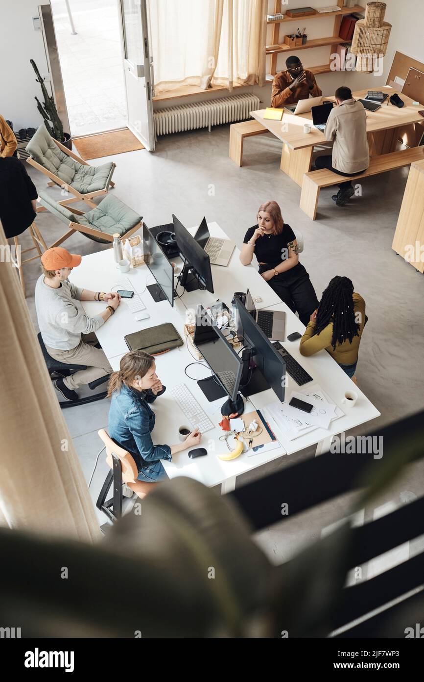 Vue en grand angle des collaborateurs en démarrage travaillant ensemble au bureau Banque D'Images