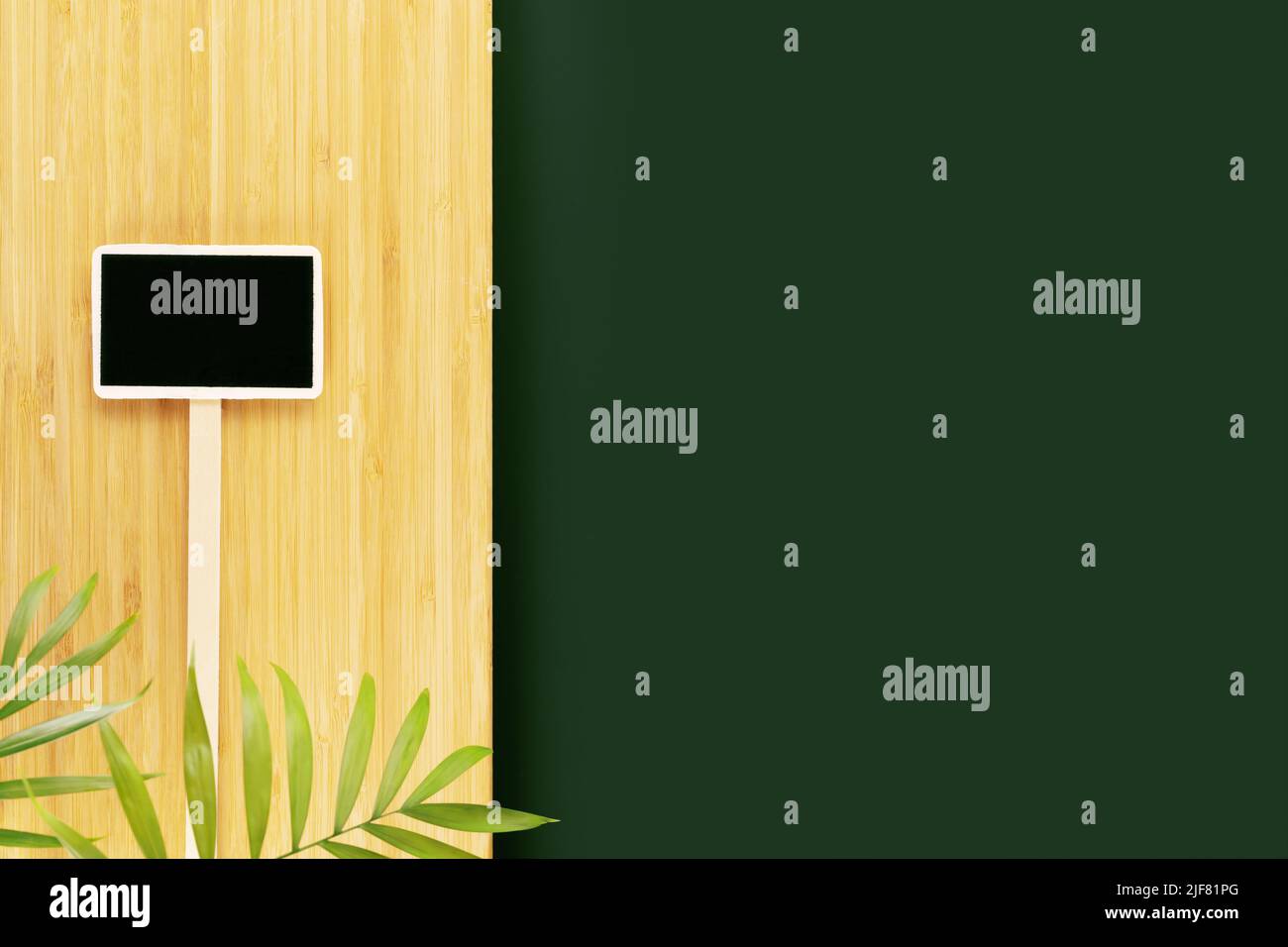 Environnement écologique et naturel. Table vide vert foncé et plateau de cuisine en bois avec feuilles de palmier et tableau noir. Maquette pour affichage ou montage de s. Banque D'Images Environnement écologique et naturel. Table vide vert foncé et plateau de cuisine en bois avec feuilles de palmier et tableau noir. Maquette pour affichage ou montage de s. Banque D'Images