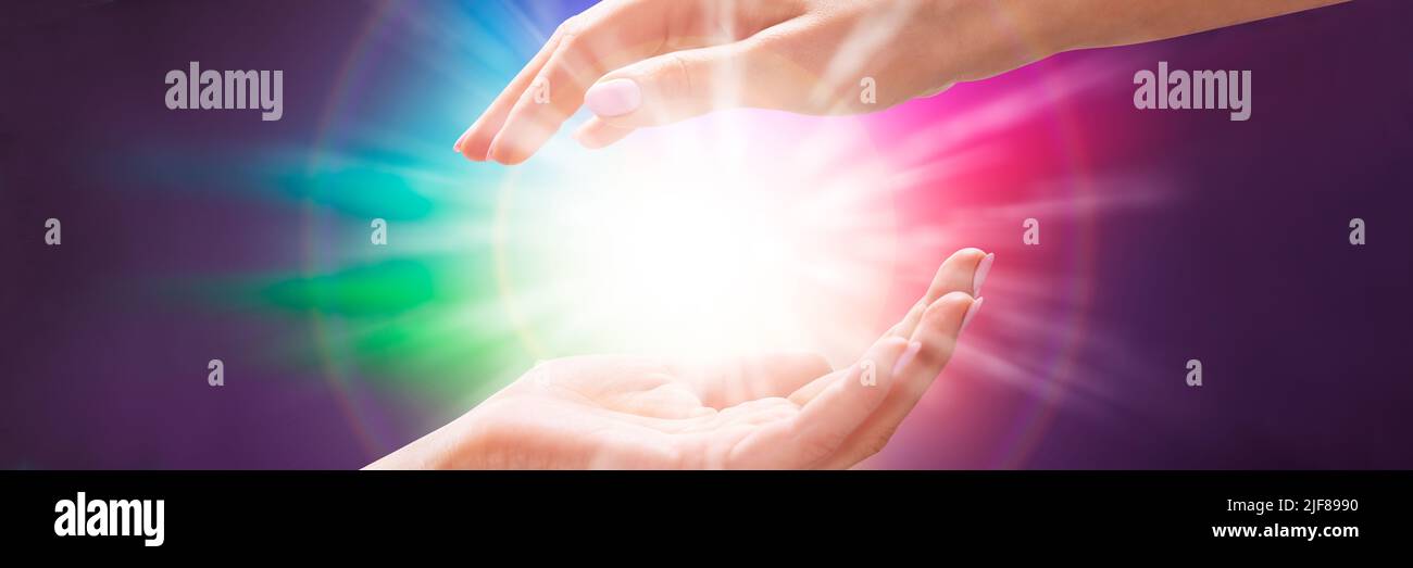 Close-up of a Woman's Hand Holding Light Against Colorful Background Banque D'Images