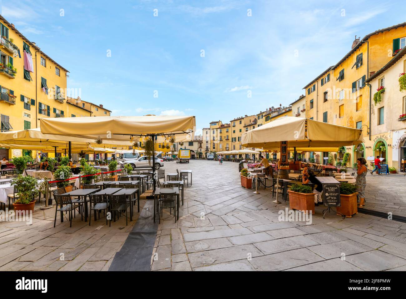 Cafés-terrasses à l'intérieur de la Piazza del Anfiteatro, l'ancien amphithéâtre de la ville toscane fortifiée de Lucques, en Italie. Banque D'Images