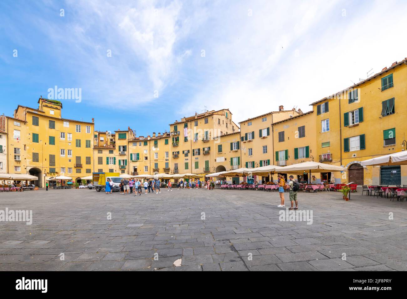Cafés-terrasses à l'intérieur de la Piazza del Anfiteatro, l'ancien amphithéâtre de la ville toscane fortifiée de Lucques, en Italie. Banque D'Images