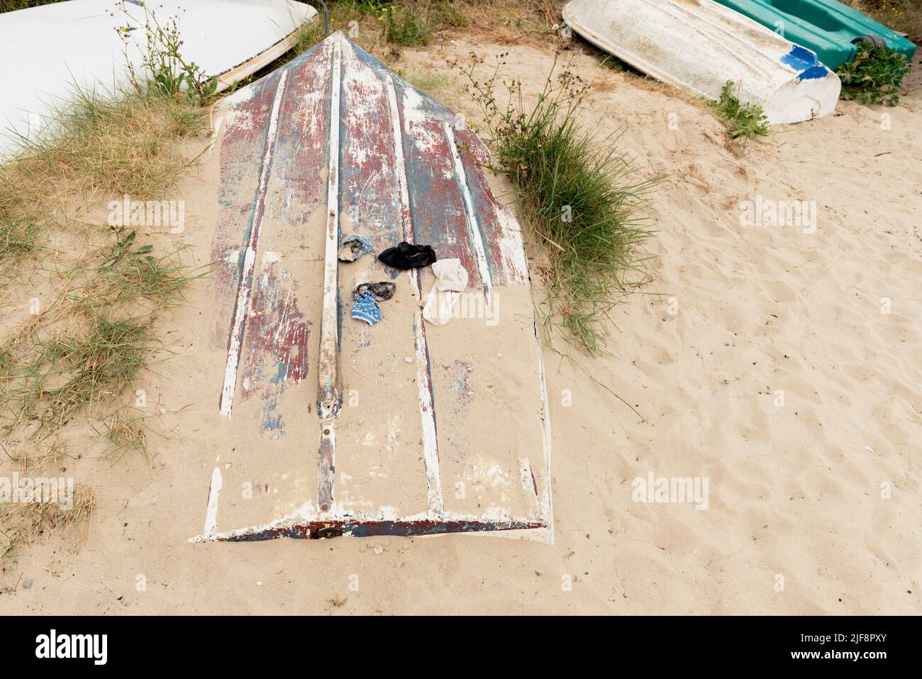 Chaussettes perdues sur bateau partiellement couvertes de sable Banque D'Images