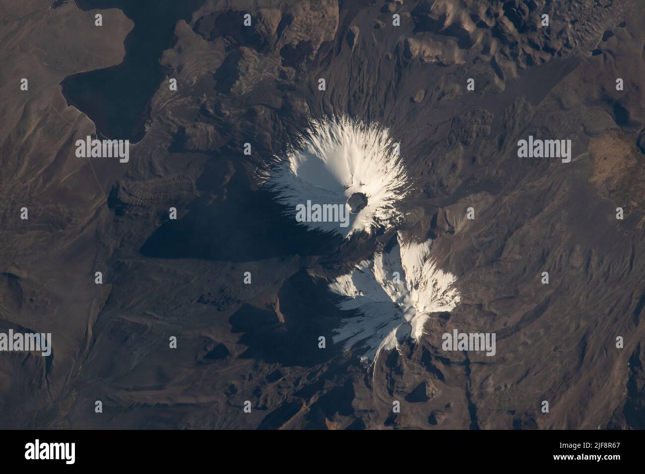 Atmosphère terrestre. 21st juin 2022. Les stratovolcans Parinacota et Pomerape (de haut en bas) sont représentés à partir de la Station spatiale internationale alors qu'elle était en orbite à 263 miles au-dessus de la nation sud-américaine du Chili. Parinacota est un volcan dormant sur la frontière Chili-Bolivie et son pic est d'environ 20 800 pieds. Pomerape, dernière activité il y a plus de 100 000 ans, est également sur la frontière Chili-Bolivie avec une altitude d'environ 20 600 pieds. En haut à gauche, se trouve le lac‡ Chungar dans le nord du Chili, qui se trouve à environ 14 800 pieds au-dessus du niveau de la mer. Credit: NASA/ZUMA Press Wire Service/ZUMAPRESS.com/Alamy Live News Banque D'Images