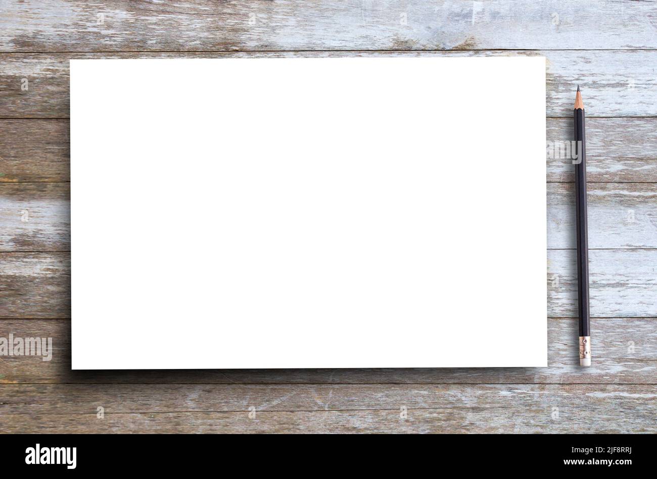 Vue de dessus papier blanc vierge et crayon noir sur un arrière-plan et une texture en bois anciens avec espace de copie pour n'importe quel modèle. Banque D'Images