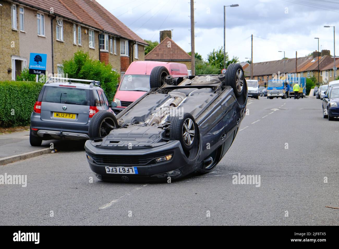 Une voiture renversée au milieu de la route, après avoir été suivie par la police, attend son enlèvement. Banque D'Images