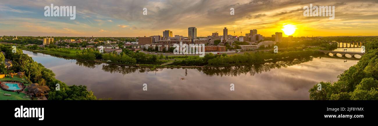 Vue aérienne du centre-ville du Nouveau-Brunswick et de l'université Rutgers tandis que le soleil se couche derrière les édifices de la haute élévation et se reflète sur la rivière Raritan Banque D'Images