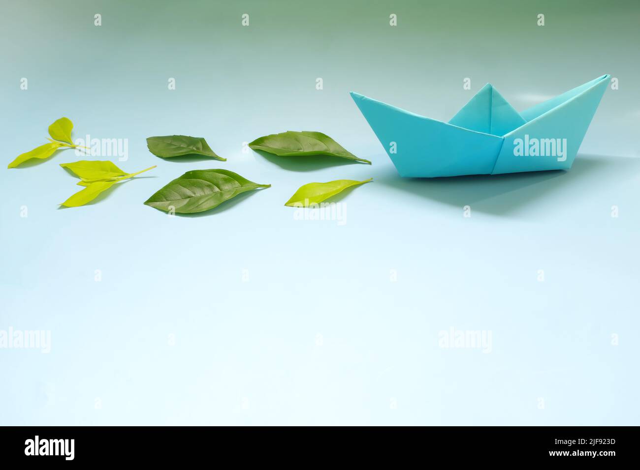 Énergie propre pour le transport maritime et le transport de marchandises et le transport maritime durable. Bateau en papier émettant des feuilles vertes fraîches. Banque D'Images