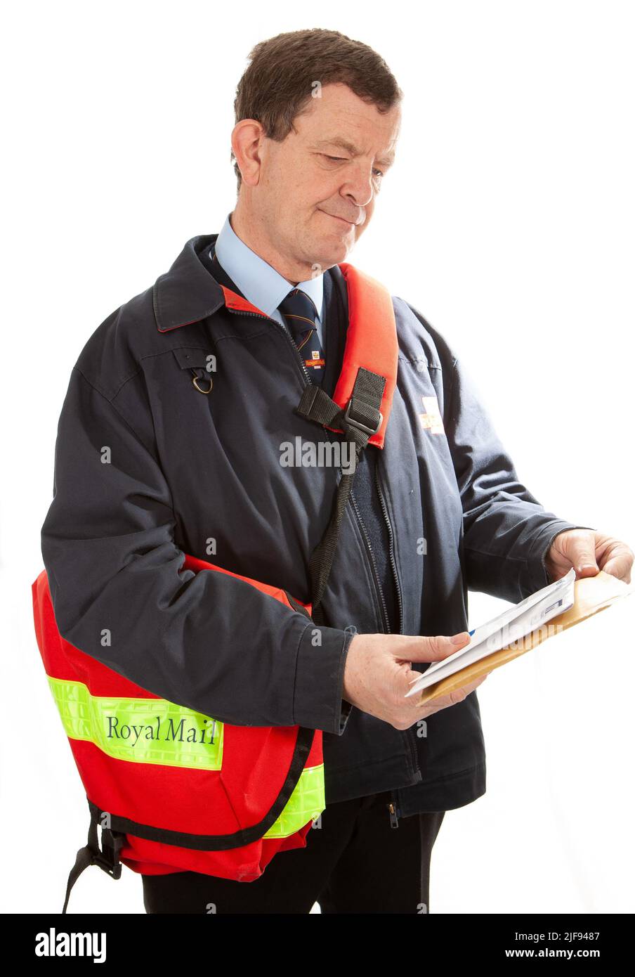 Un travailleur postal britannique en uniforme triant son courrier sur son tour. Partie d'une série d'images avec le même modèle de caractère. Banque D'Images